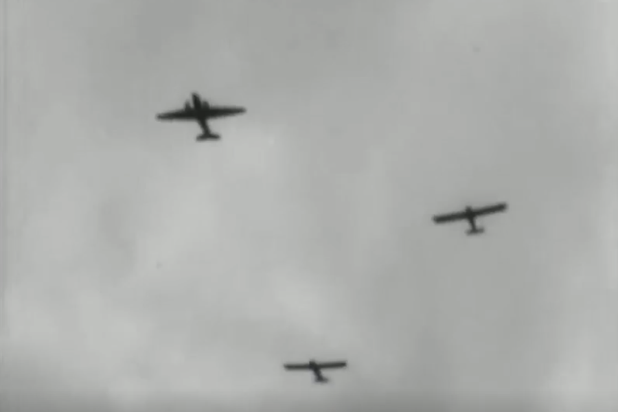 Four aeroplanes are flying in formation against a cloudy sky, viewed from below in a black and white image.